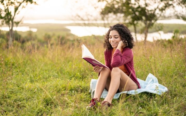 Girl reading Italian fairy tale in the field - The Proud Italian