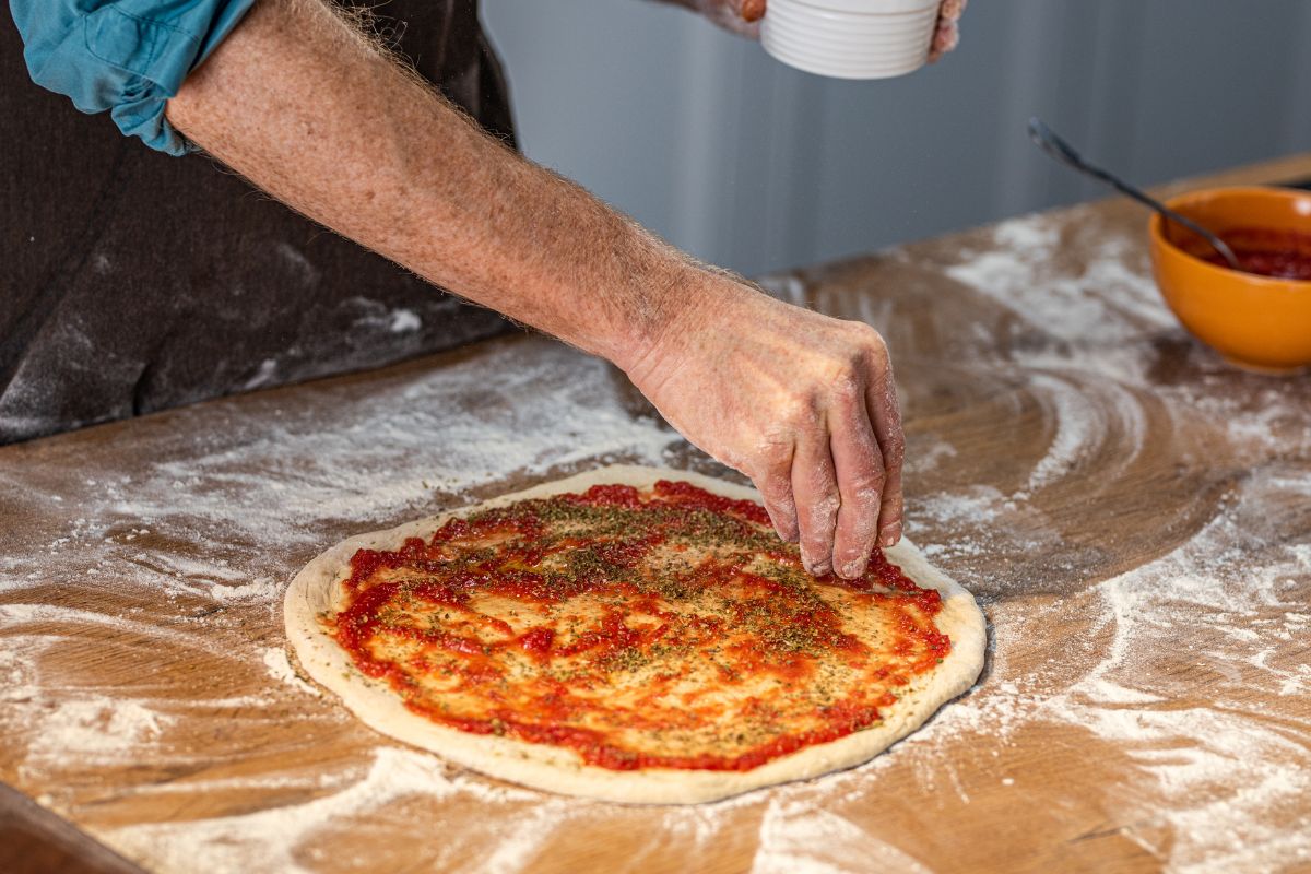Chef seasoning pizza dough