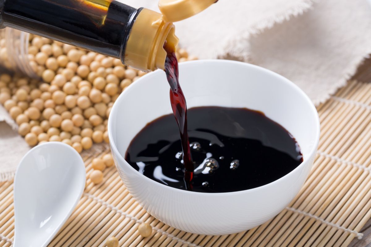 Pouring soy sauce into white bowl