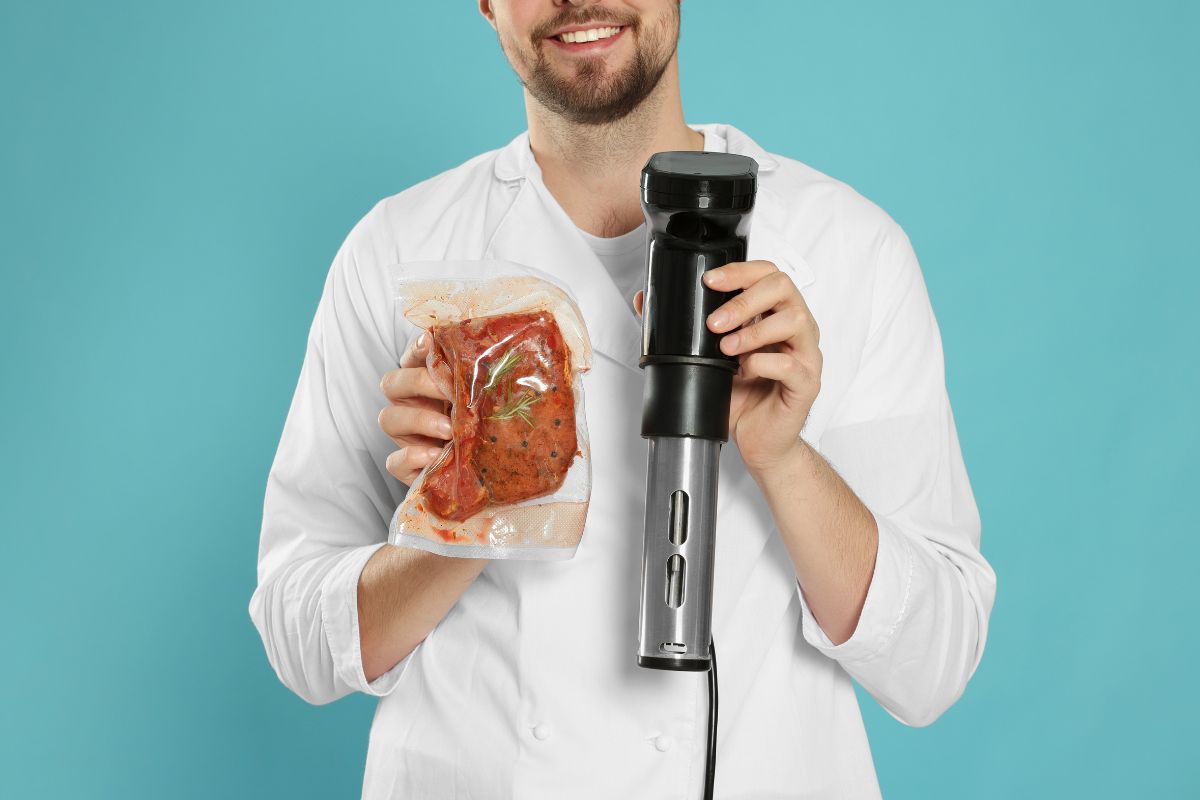 Chef holding sous vide machine and meat